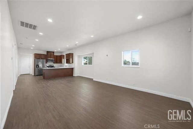 301 Kincaid St, Bakersfield, CA 93307 - unfurnished living room with dark wood-style floors, baseboards, and recessed lighting