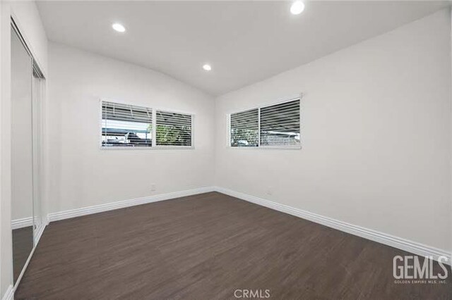 301 Kincaid St, Bakersfield, CA 93307 - unfurnished bedroom with dark wood finished floors, baseboards, recessed lighting, vaulted ceiling, and a closet