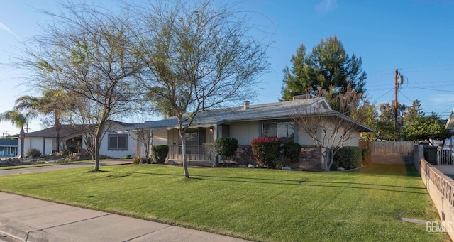 ranch-style home featuring brick siding, fence, driveway, and a front lawn