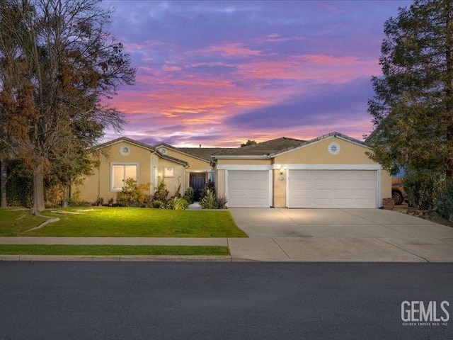 single story home with a garage and a yard