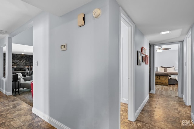 hallway with baseboards and visible vents