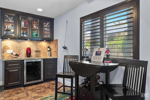 bar featuring tasteful backsplash, a bar, a healthy amount of sunlight, and wine cooler
