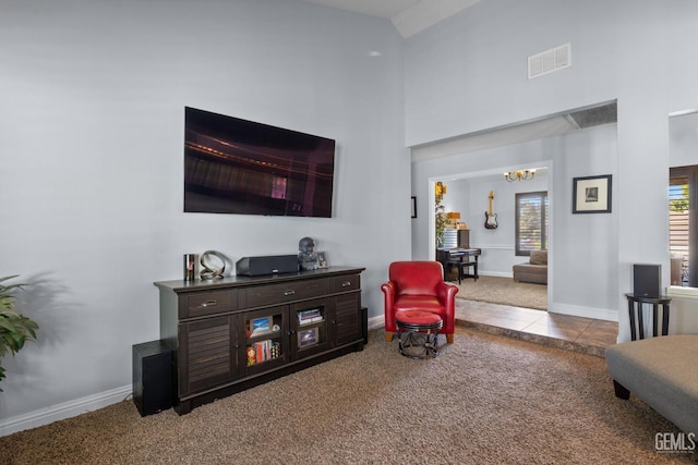 sitting room with carpet floors, high vaulted ceiling, a chandelier, baseboards, and visible vents