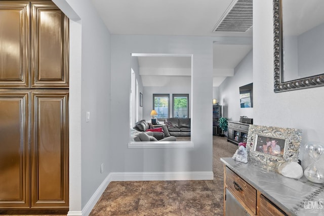 hallway featuring baseboards and visible vents