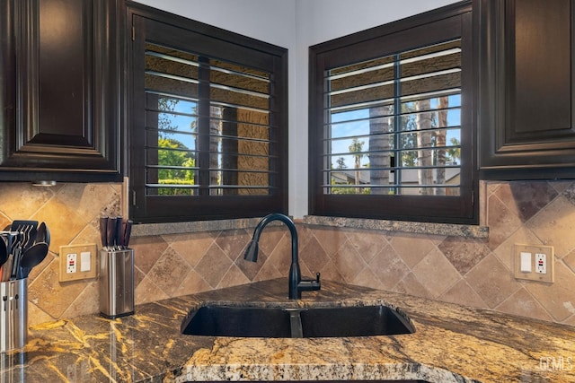 kitchen featuring a sink, decorative backsplash, and a healthy amount of sunlight