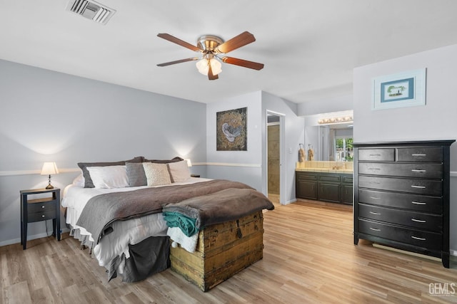 bedroom with a ceiling fan, visible vents, baseboards, light wood finished floors, and connected bathroom