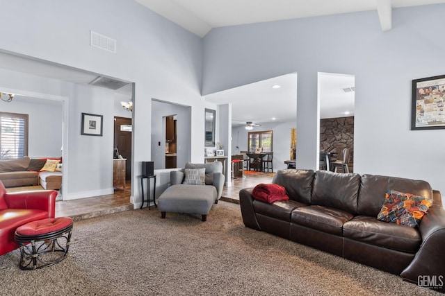 living area with visible vents, a healthy amount of sunlight, carpet, and ceiling fan with notable chandelier