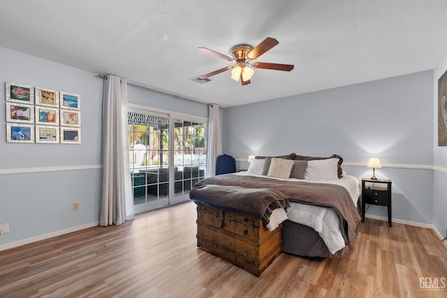 bedroom featuring baseboards, visible vents, access to exterior, and wood finished floors