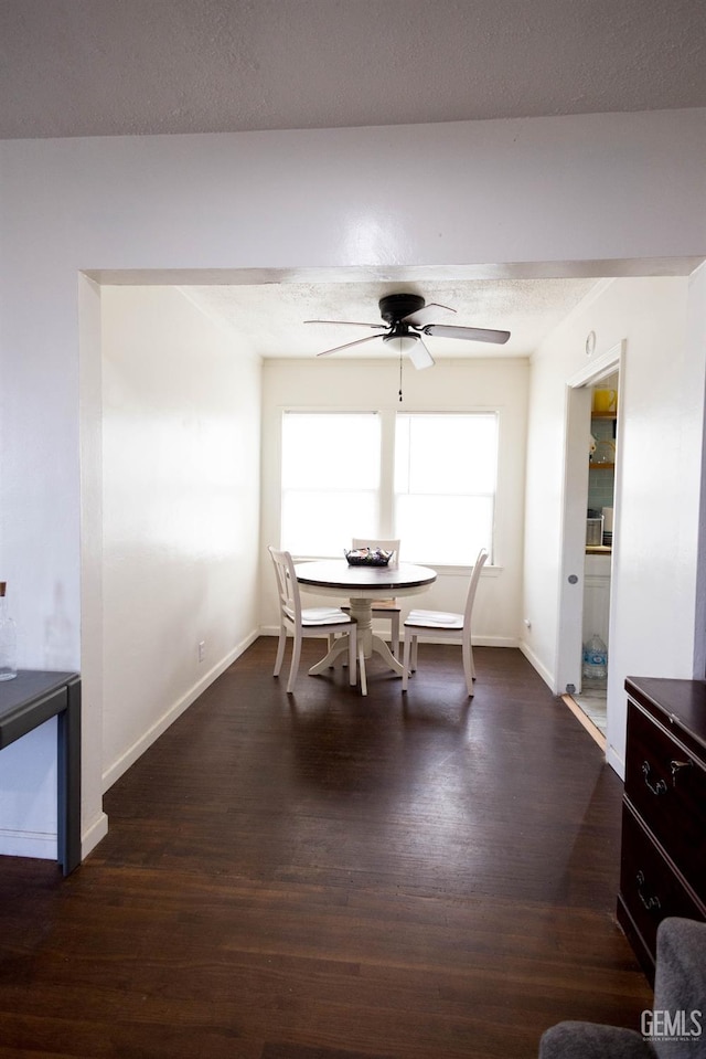 dining area with baseboards, a textured ceiling, a ceiling fan, and wood finished floors