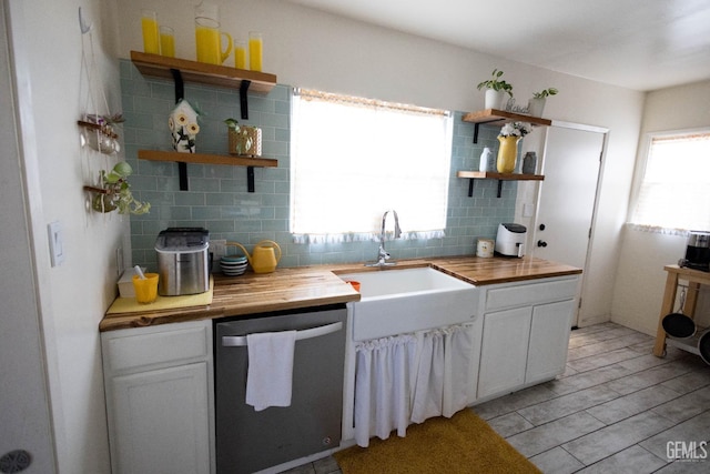 kitchen with decorative backsplash, dishwasher, butcher block countertops, open shelves, and a sink