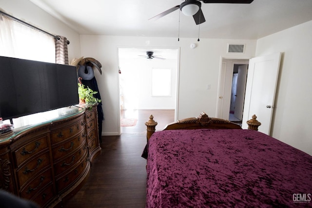 bedroom with a ceiling fan, dark wood-style flooring, visible vents, and multiple windows