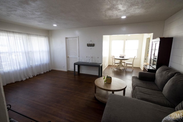 living room with a textured ceiling, baseboards, wood finished floors, and recessed lighting