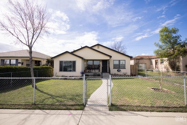 view of front of house with a front lawn, a fenced front yard, a gate, and stucco siding