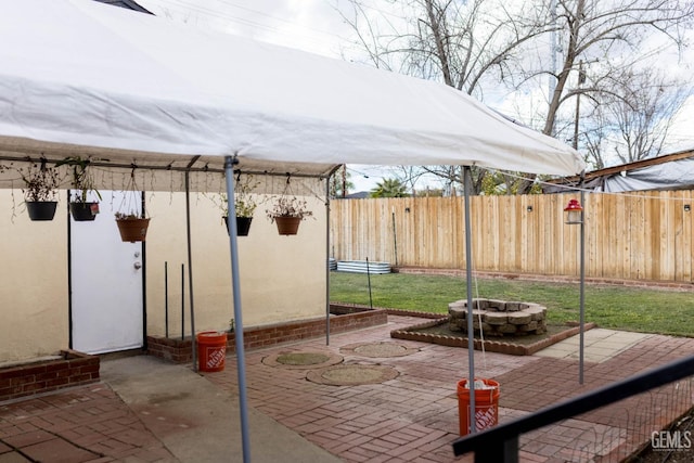 view of patio with an outdoor fire pit and fence