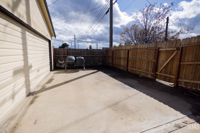 view of patio featuring fence and a gate