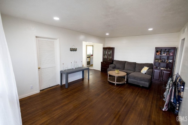 living area with a textured ceiling, baseboards, wood finished floors, and recessed lighting