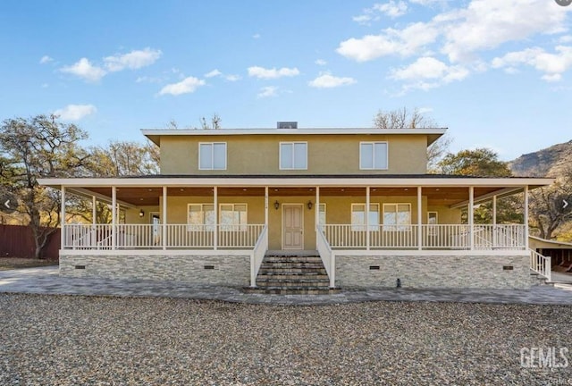 farmhouse-style home featuring covered porch, a patio area, and stucco siding