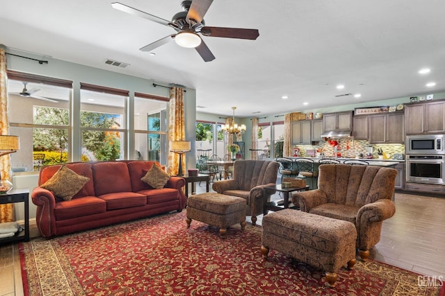 living room featuring dark hardwood / wood-style floors and ceiling fan with notable chandelier