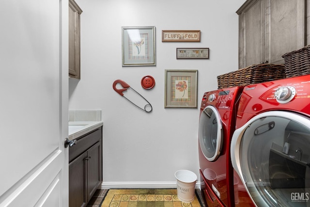 clothes washing area featuring cabinets and washing machine and dryer