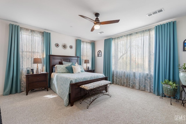 carpeted bedroom with multiple windows and ceiling fan