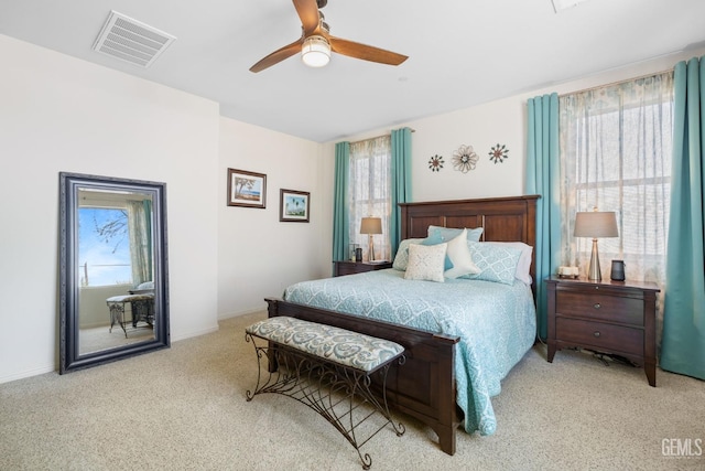 bedroom featuring multiple windows, ceiling fan, and light carpet