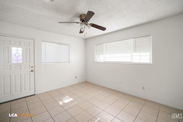 foyer featuring ceiling fan, light tile patterned floors, and a textured ceiling