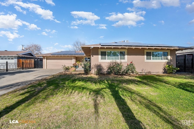 single story home featuring a garage, a front yard, and solar panels