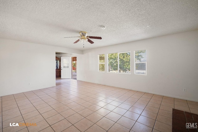 tiled empty room with a textured ceiling and ceiling fan