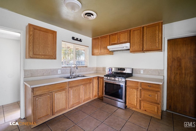 kitchen with tile patterned flooring, sink, and stainless steel gas range