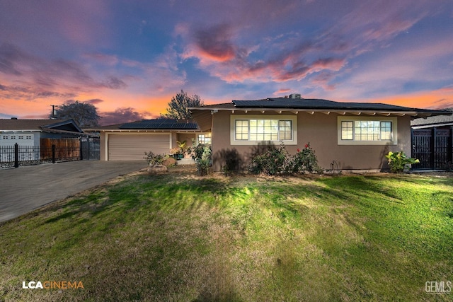 view of front of house featuring a yard, a garage, and solar panels