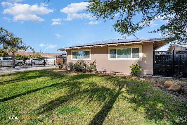 view of front of home with a front yard and solar panels