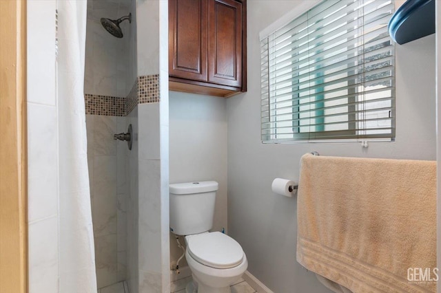full bathroom featuring a shower stall, toilet, and baseboards