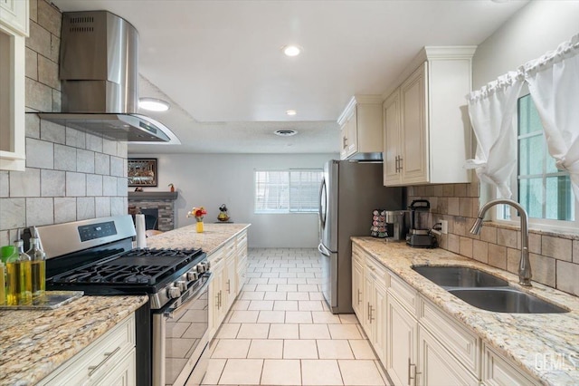 kitchen with wall chimney exhaust hood, decorative backsplash, stainless steel appliances, and a sink