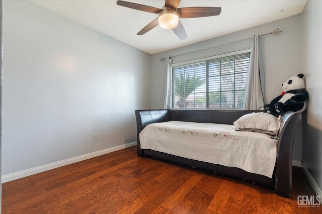 bedroom featuring baseboards, wood finished floors, and ceiling fan