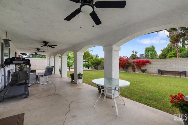view of patio with a fenced backyard, a ceiling fan, and outdoor dining space