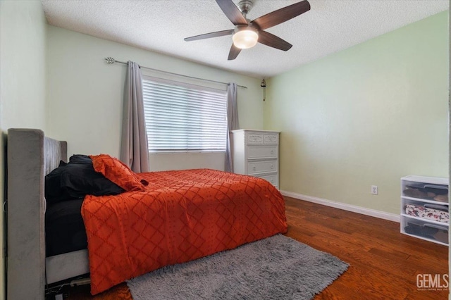 bedroom with wood finished floors, a textured ceiling, a ceiling fan, and baseboards