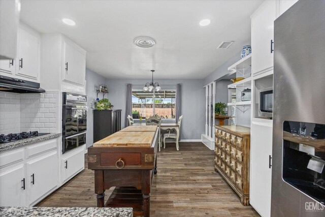 4418 Kevin Dr, Bakersfield, CA 93308 - kitchen featuring black appliances, dark wood finished floors, decorative backsplash, a warming drawer, and a chandelier