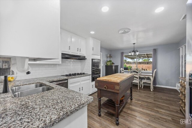 4418 Kevin Dr, Bakersfield, CA 93308 - kitchen with under cabinet range hood, white cabinetry, backsplash, dark wood-type flooring, and recessed lighting