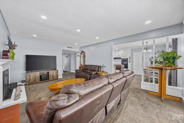 4418 Kevin Dr, Bakersfield, CA 93308 - living room featuring carpet flooring, a textured ceiling, recessed lighting, a glass covered fireplace, and a chandelier