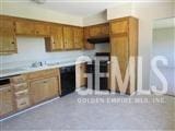 kitchen with black dishwasher, light countertops, and brown cabinetry