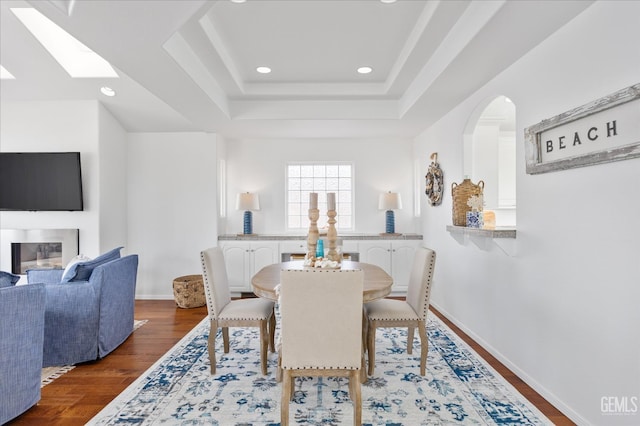 48 16th St, Cayucos, CA 93430 - dining space featuring dark wood-style floors, recessed lighting, a tray ceiling, arched walkways, and a skylight