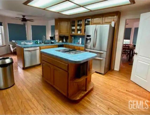 kitchen featuring ceiling fan, a center island, light hardwood / wood-style flooring, and appliances with stainless steel finishes