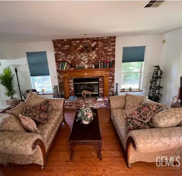 living room featuring a healthy amount of sunlight, wood-type flooring, and a fireplace