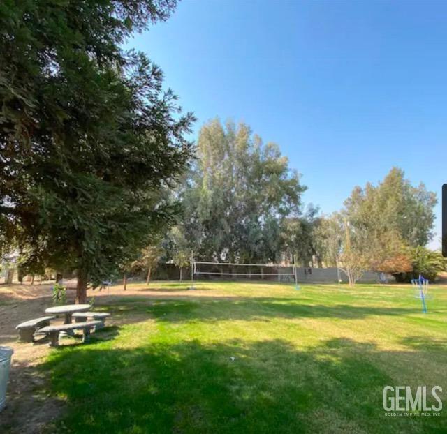 surrounding community with a lawn and volleyball court