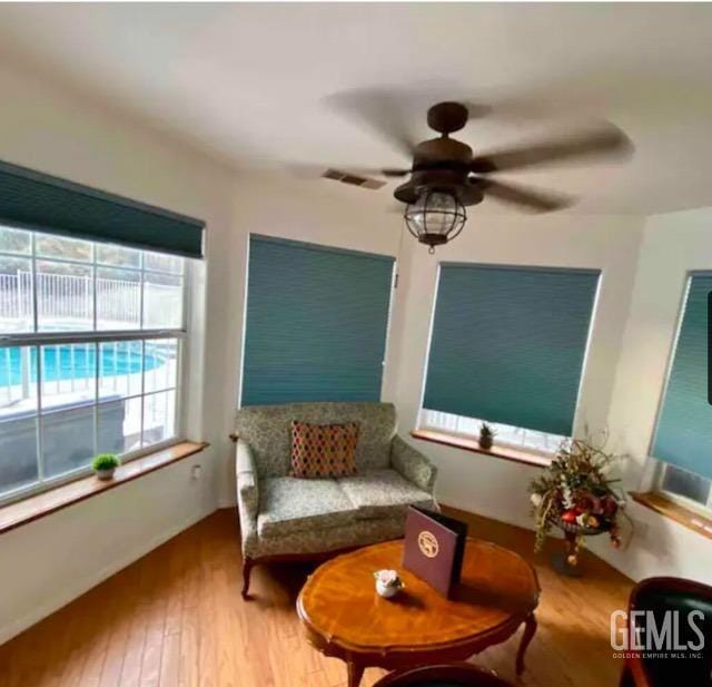 sitting room featuring ceiling fan and hardwood / wood-style floors