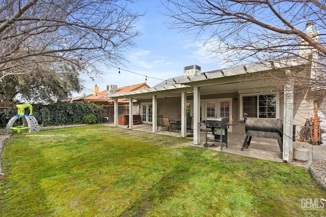 back of house featuring a patio, a playground, fence, a yard, and stucco siding