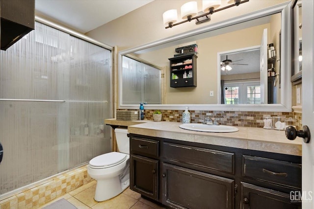 bathroom with toilet, a shower with shower door, decorative backsplash, and vanity