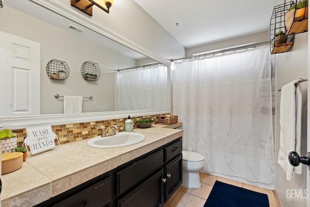 bathroom with tasteful backsplash, visible vents, toilet, vanity, and tile patterned floors