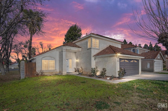 mediterranean / spanish-style house featuring a lawn and a garage