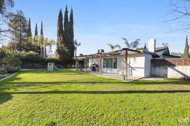 rear view of house with a patio and a yard